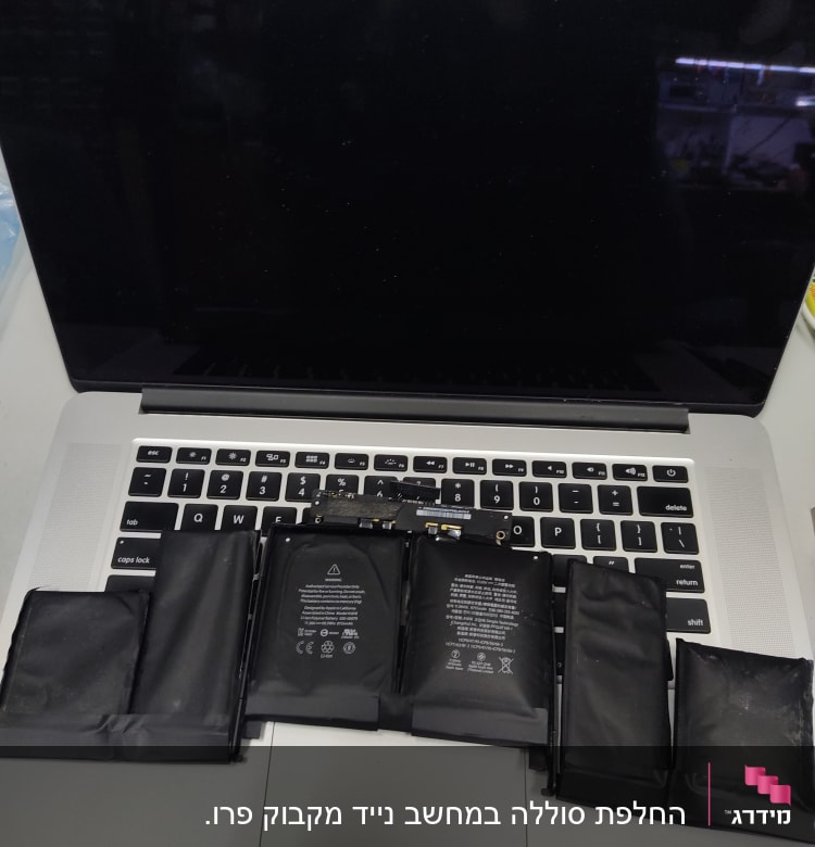 סוללת מחשב נייד מונחת על מקלדת מחשב נייד